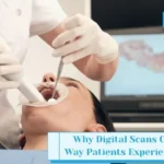 Dentist performing digital dental scan with intraoral scanner while patient views 3D teeth model on screen