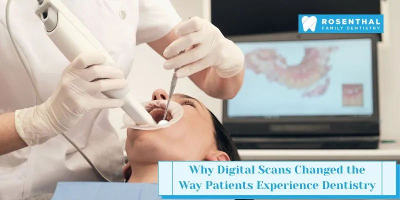 Dentist performing digital dental scan with intraoral scanner while patient views 3D teeth model on screen